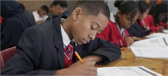Learner writing answers in a workbook